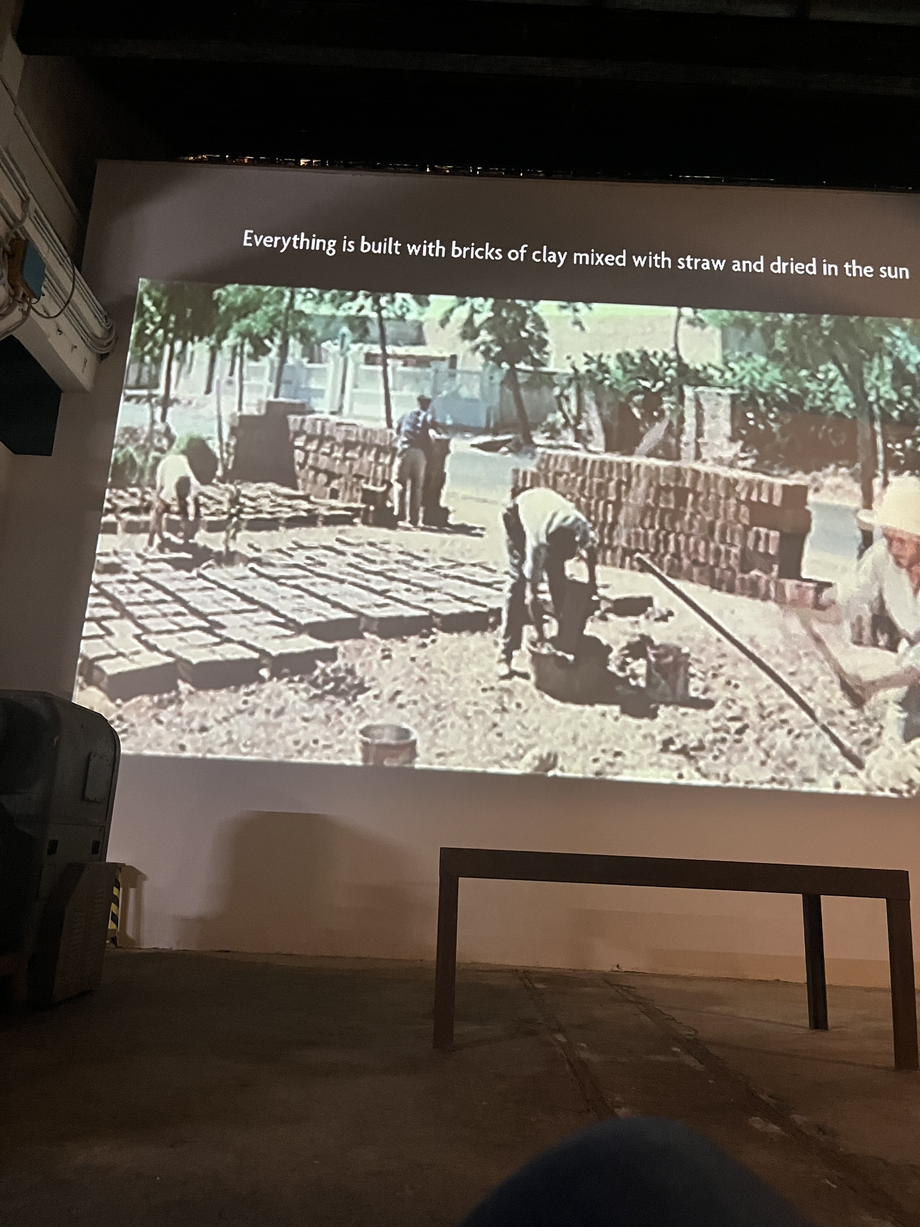 Archival film projection showing brick construction of the village