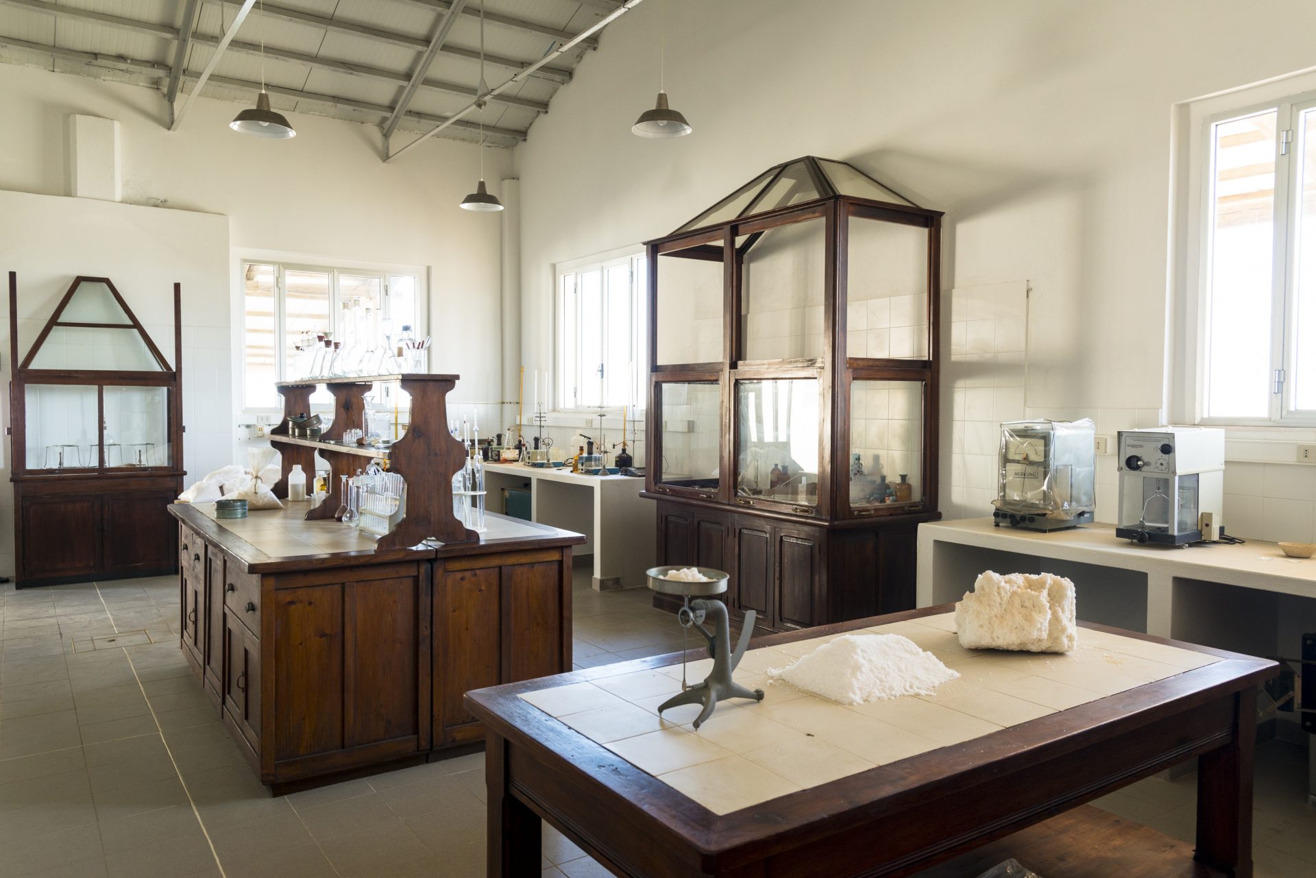 The restored chemical laboratory in the workers' village, with original wooden cabinetry and salt samples on the tiled workbench